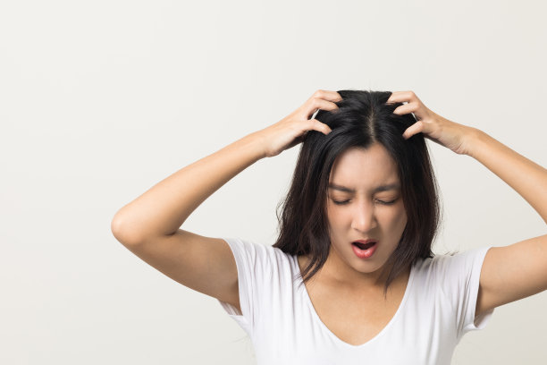 年轻女子头部发痒头皮上有一种真菌头皮屑，红疹子她挠挠头来缓解。需要看医生。头发问题脱发。在孤立的背景下拍摄图片下载