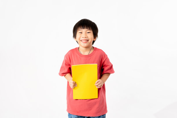 快乐亚洲男孩的肖像与书籍隔离在白色背景，教育和学习与技术的概念图片下载