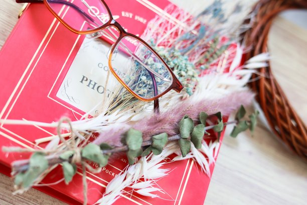 红色相册上放着玻璃杯和干花图片下载