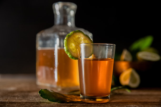 朗姆酒杯烈酒和酒瓶在深色木质背景下，富有豪华的酒吧氛围图片下载