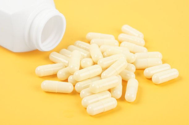 黄色药用胶囊黄色背景。图片下载