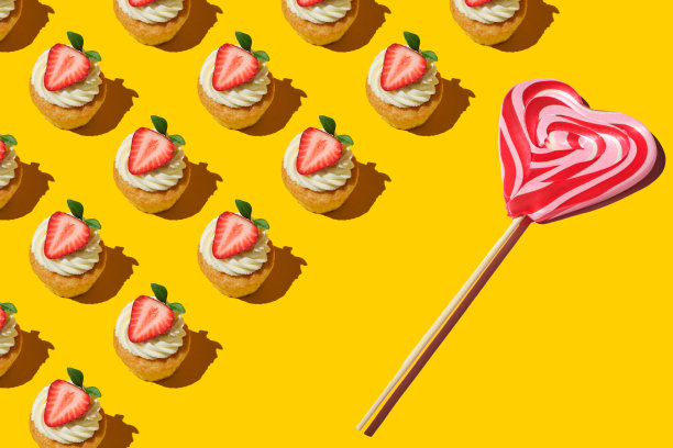 用黄色背景上的草莓和心形棒棒糖做成的家庭饼干图案。上面有大草莓的小蛋糕。红色和白色条纹的甜棒棒糖。平的风格。图片下载