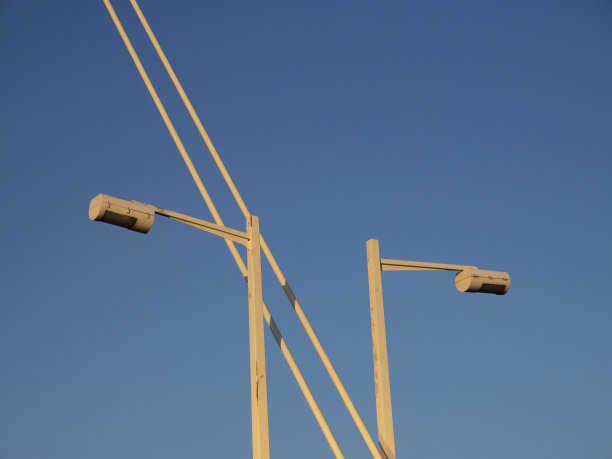 夕阳照亮了桥上的电线和街灯。图片下载