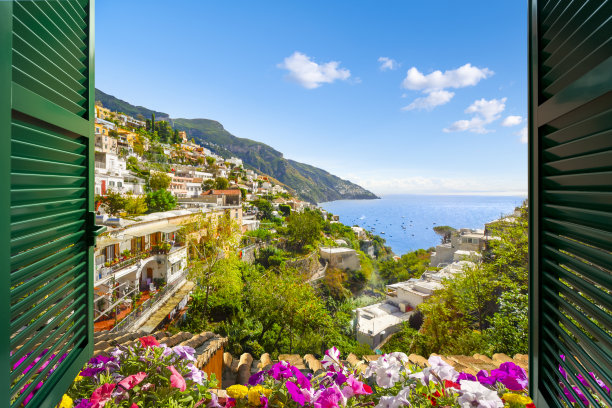 夏季，意大利南部阿马尔菲海岸的波西塔诺市(Positano)，透过百叶窗敞开的窗户，可以欣赏到山景、城市和海景。图片下载