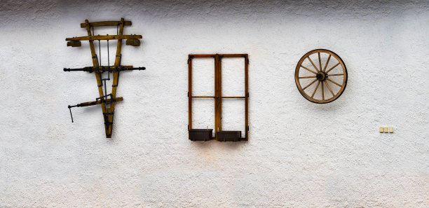 白墙上有3件古老的木制文物。图片下载