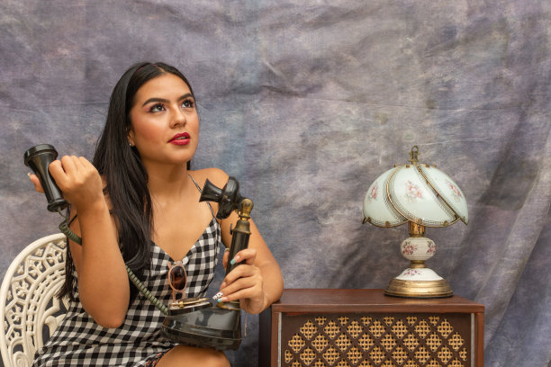 拉丁女人的肖像，在别针看拿着一个旧手机。复古复古风格场景图片下载