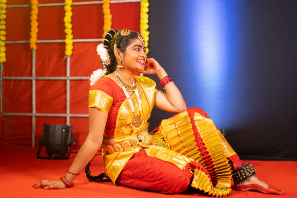 年轻的bharatnatyam舞者在跳舞后笑着坐在舞台上-休息，放松和专业舞者的概念。图片下载