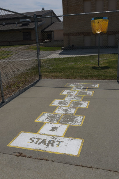 蒙大拿州一个小镇的学校在混凝土户外篮球场进行跳房子游戏图片下载