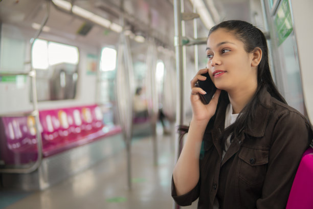 美丽的年轻女子在乘坐神威地铁时用手机通话。图片下载