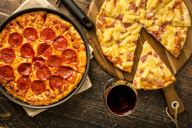 木桌上放着夏威夷披萨和意大利辣香肠披萨图片下载