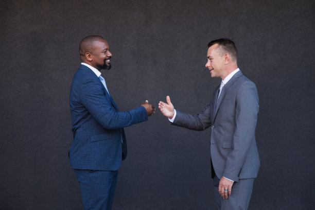 快乐的同事们靠在灰色的墙上图片下载