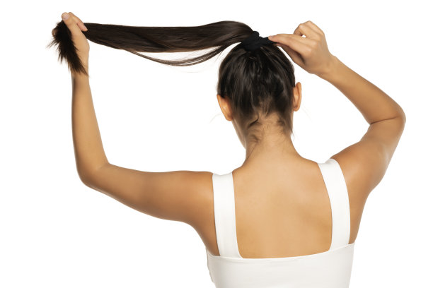 后视图的年轻女子调整她的头发在马尾辫图片下载