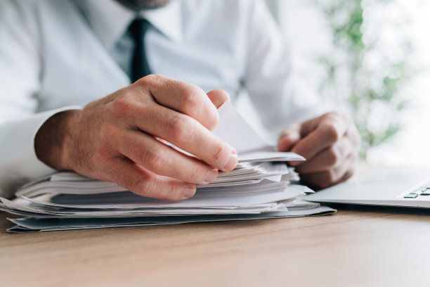 HR经理正在看办公桌上成堆的求职者简历图片下载