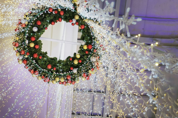 绿色的树叶用水晶彩球装饰圣诞树，点缀着闪闪发光的彩灯。图片下载