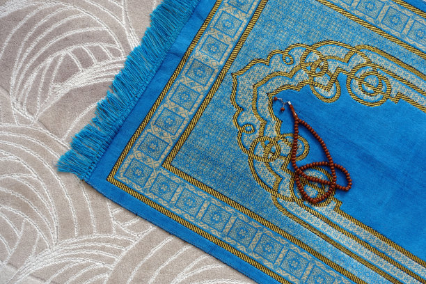 一个蓝色的祈祷地毯，在房子里，一个穆斯林，他的念珠，旁边，一个祈祷地毯，伊斯兰教的礼拜，图片下载