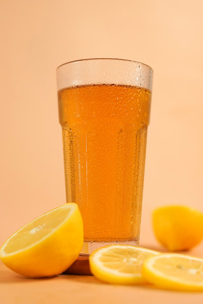 在带露珠的杯子里泡着诱人的茶。酒楼设有饮料照片，适合菜单展示。木盘上的一杯柠檬茶。图片下载