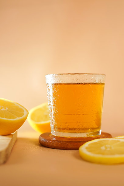 在带露珠的杯子里泡着诱人的茶。酒楼设有饮料照片，适合菜单展示。木盘上的一杯柠檬茶。图片下载