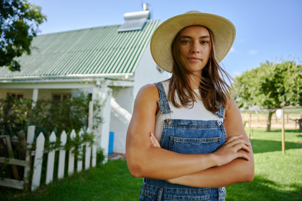 白人女性农民站在户外，双臂交叉图片下载