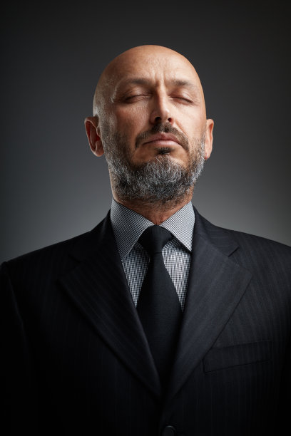 一个留着胡须的中年商人闭着眼睛，享受着片刻的宁静图片下载