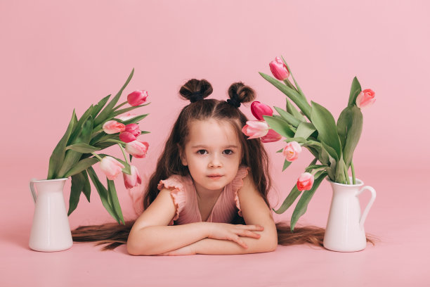 粉红色背景上的郁金香女孩的肖像。图片下载