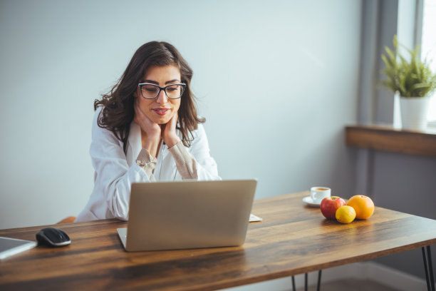 女营养师坐在她的办公室里为病人提供在线咨询。图片下载