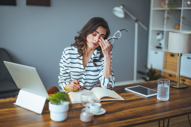 一名年轻的女商人在她的笔记本电脑上工作时看起来很紧张。图片下载