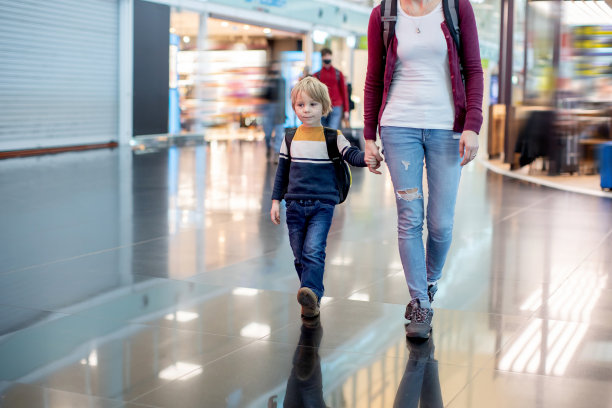 可爱的小男孩在机场登机口附近的中转大厅等待登机。积极的家庭生活方式与孩子乘飞机旅行图片下载