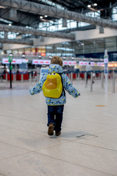 可爱的小男孩在机场登机口附近的中转大厅等待登机。积极的家庭生活方式与孩子乘飞机旅行图片下载