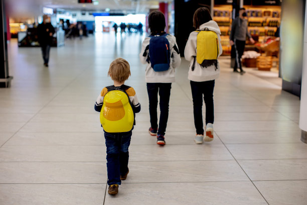 可爱的小男孩在机场登机口附近的中转大厅等待登机。积极的家庭生活方式与孩子乘飞机旅行图片下载