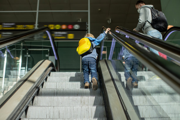 可爱的小男孩在机场登机口附近的中转大厅等待登机。积极的家庭生活方式与孩子乘飞机旅行图片下载