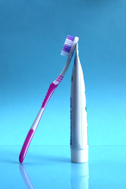 牙膏和刷子站在蓝色的背景上图片下载