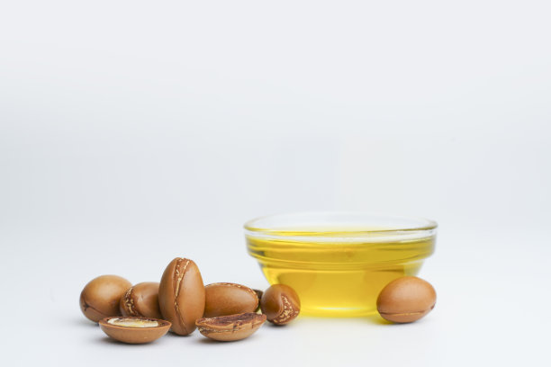 在白色背景上分离出摩洛哥坚果种子和油。植物油坚果。化妆品和天然油脂背景图片下载
