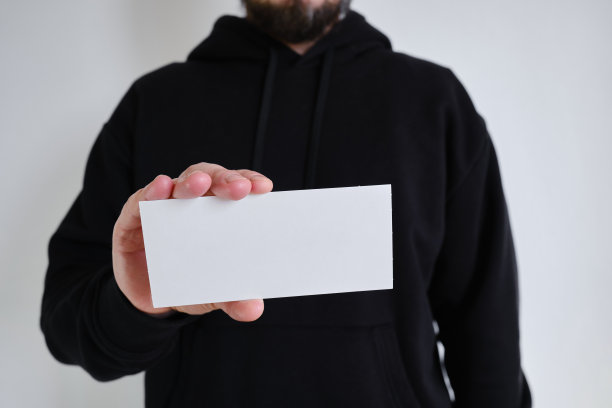 白色的空牌在一个男人的手中在黑色的背景上。放置文字和广告。名片图片下载