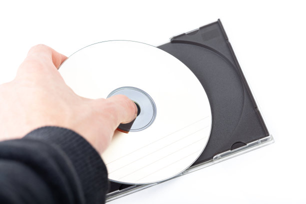 匿名男子，手拿或放入一个简单的空CD或DVD光盘在一个CD- rom盒子存储容器。电影、电影、软件、数据复制、数字媒体盗版犯罪的抽象概念图片下载