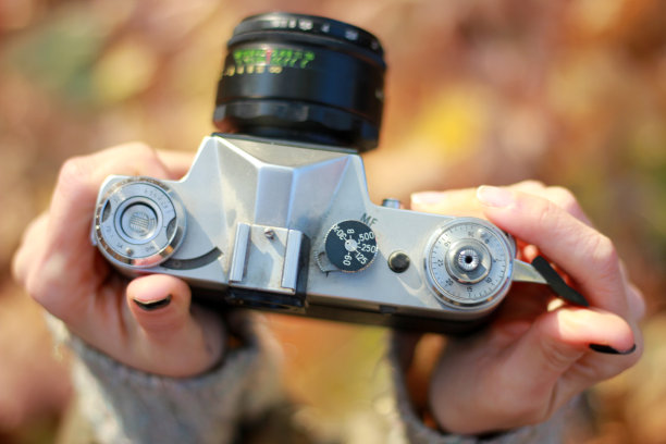 手持老式相机，背景模糊。概念:摄影课程图片下载