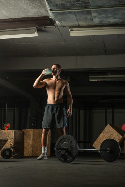 肌肉发达的男人正在喝水休息。图片下载