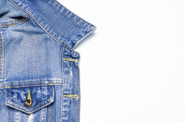 特写蓝色牛仔夹克在孤立的白色背景顶视图平面布局复制空间。牛仔布，时尚夹克，女装或男装潮流服装，时尚背景。牛仔质地图片下载