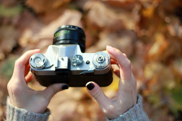 手持老式相机，背景模糊。概念:摄影课程图片下载