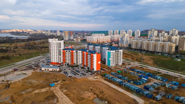 在建筑工地上空飞行。城市新建筑。板式多层建筑的建造。图片下载