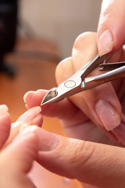 用镊子触摸手上的指甲。特写镜头。图片美容网站。有选择性的重点。图片下载