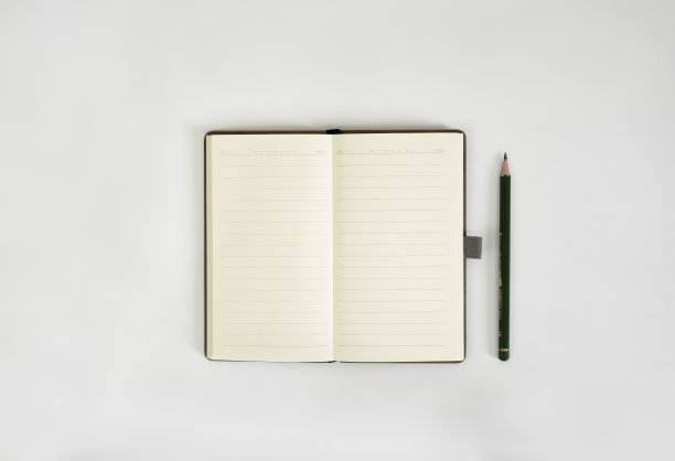 桌上放着素描本和铅笔。一个笔记本模型放在桌子上作为工作空间的布局图片下载