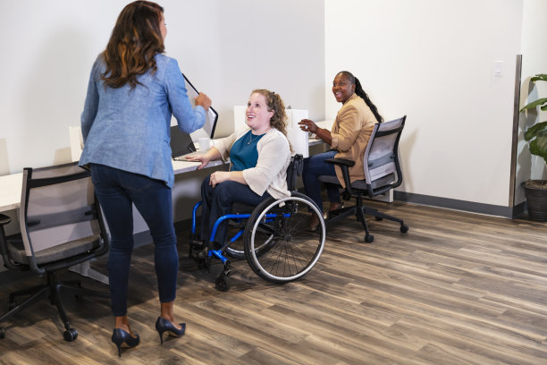 三个女商人在办公室工作，一个坐轮椅图片下载