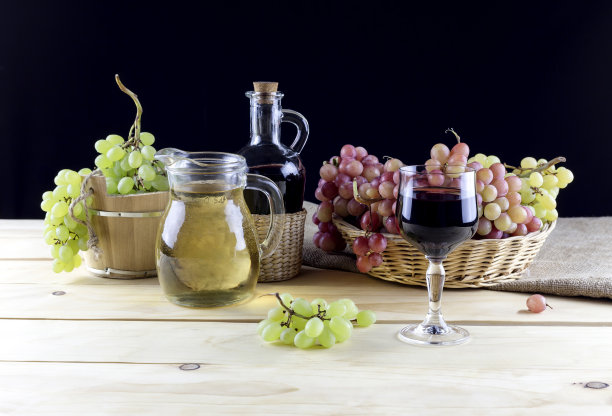 绿色和粉红色的成熟葡萄，在桌子上的杯子和葡萄酒的特写图片下载