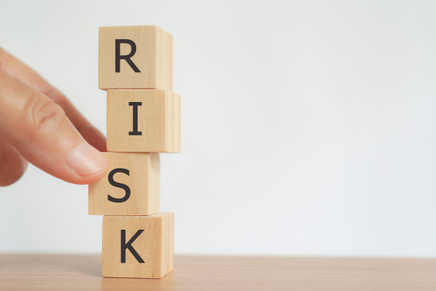 手握不稳定的木制立方体，用风险字表达企业风险管理理念图片下载