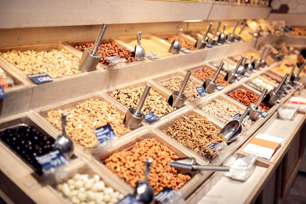 商店的柜台上卖着许多不同的坚果，都装在木箱里。榛子、大枣、核桃、葡萄干、干果等食品。自我服务。健康的素食。有选择性的重点图片下载