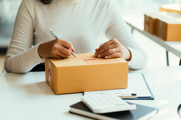 迷人美丽的亚洲青少年业主商业女性工作在家里在线购物，写订单和准备包装产品与办公设备，企业家的生活方式的概念图片下载