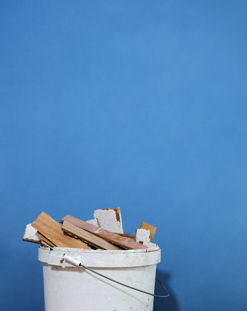 在翻修的公寓里，用电动拆卸锤将木板粘在木板上。移走的拼花木板条放置在一个容器中待处理。你在房子周围工作，以提高能源效率。图片下载