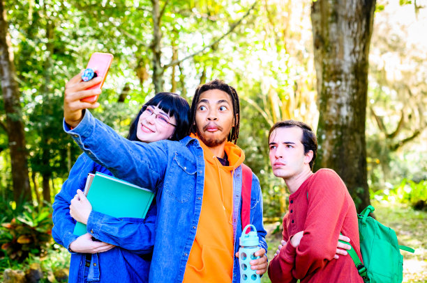 混合种族的年轻朋友，大学生，使用手机制作视频或自拍的内容创作或社交媒体图片下载