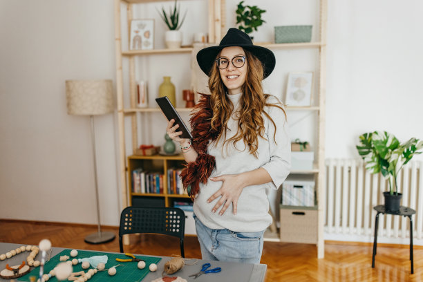 年轻的孕妇小企业主在工作室使用技术图片下载