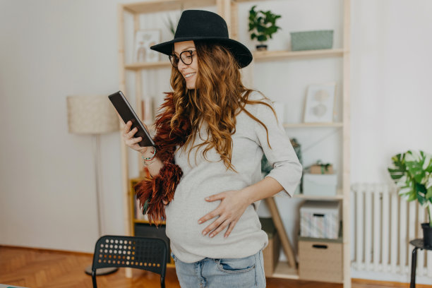 年轻的孕妇小企业主在工作室使用技术图片下载